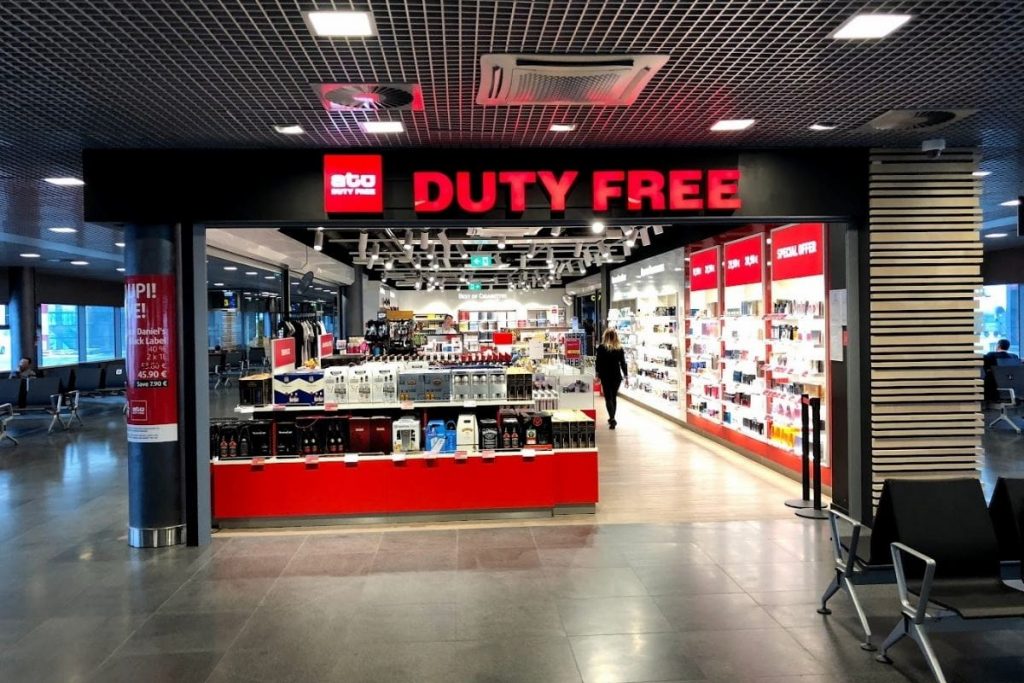 a store with red signs and a woman walking in the background